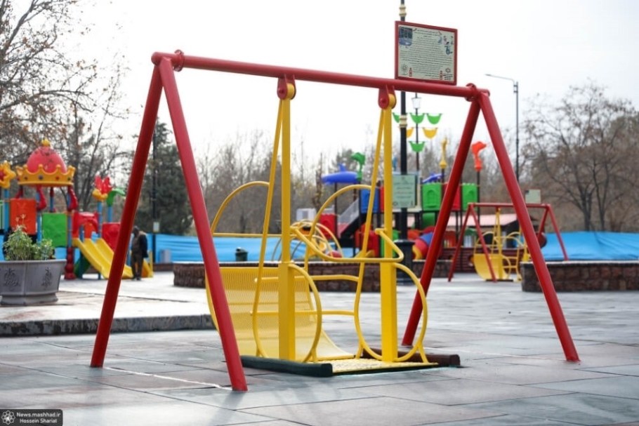 Side view of yellow and red wheelchair accessible playground equipment.