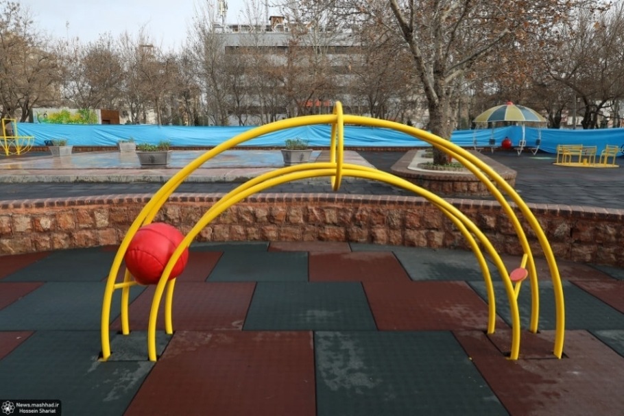 Accessible play equipment featuring a yellow arch with a red ball in the playground.
