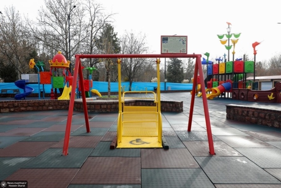 Front view of yellow and red wheelchair accessible playground equipment.