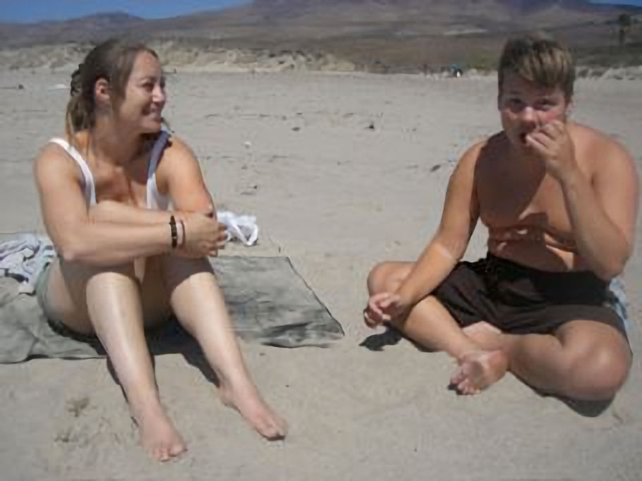 The author, Tsara Shelton, and her brother Dar sitting on the beach getting bug bites and sunburns for sensory pain and exploration.