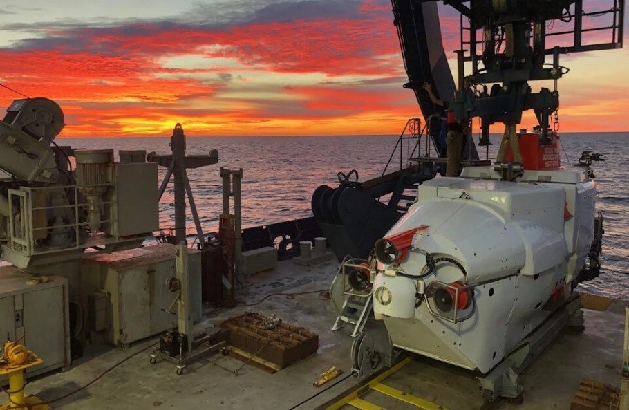 Alvin deep-sea submersible on the deck of a ship at sunrise.
