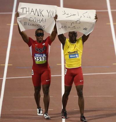 David Brown of USA holds up a banner after the Men's 100m T11 final