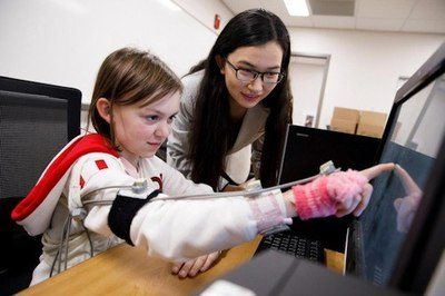 IU Ph.D. student Di Wu directs a volunteer as she touches images on a screen using a device designed to track miniscule fluctuation in the arm's movement. IU-led research suggest physical movement is an accurate method to diagnose neurodevelopmental disorders, including autism - Image Credit: James Brosher, Indiana University.