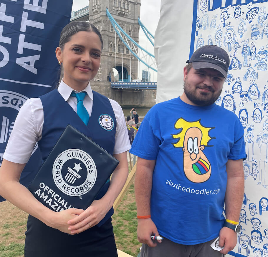 This image captures Alex the Doodler at a Guinness World Records event beside an official Guinness World Records adjudicator, who is dressed in the organization’s distinctive uniform and holding a branded folder.