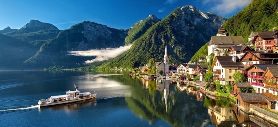 Boat on a mountain lake in Austria. The village of Hallstatt can be seen on the right side.