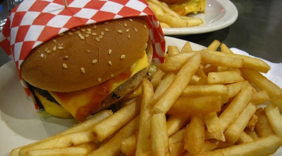 Image of junk food consisting of a hamburger and fries.
