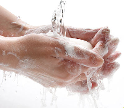 Picture shows hands covered with soap under running water.