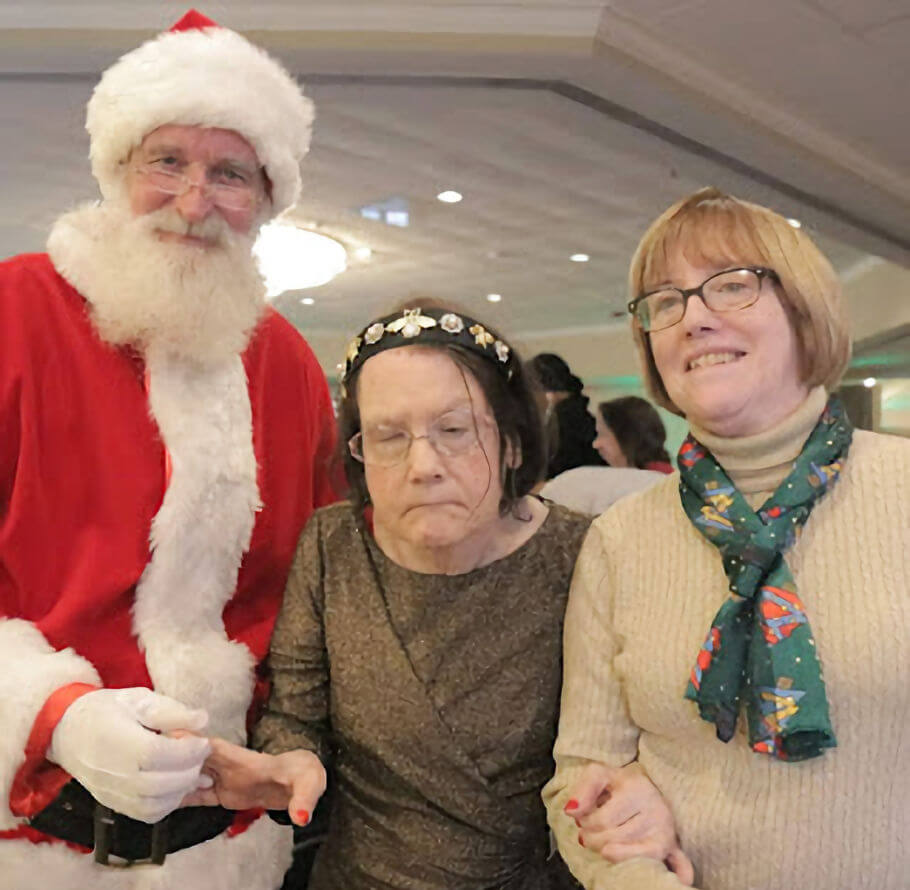 Two sisters next to Santa Claus.