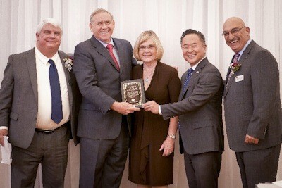 (Pictured) The Honorable Greig Smith and wife, accepting the Anne V. Finn award from (left to right) John Vescovo, Executive Vice President, Bank of Santa Clarita; John Lee, L.A. City Councilman (District 12); and Lieutenant Irwin Rosenberg, LAPD.