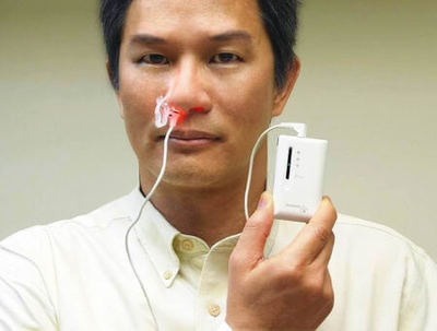 Man demonstrates nasal use of low-level laser therapy (LLLT) with intranasal irradiation.