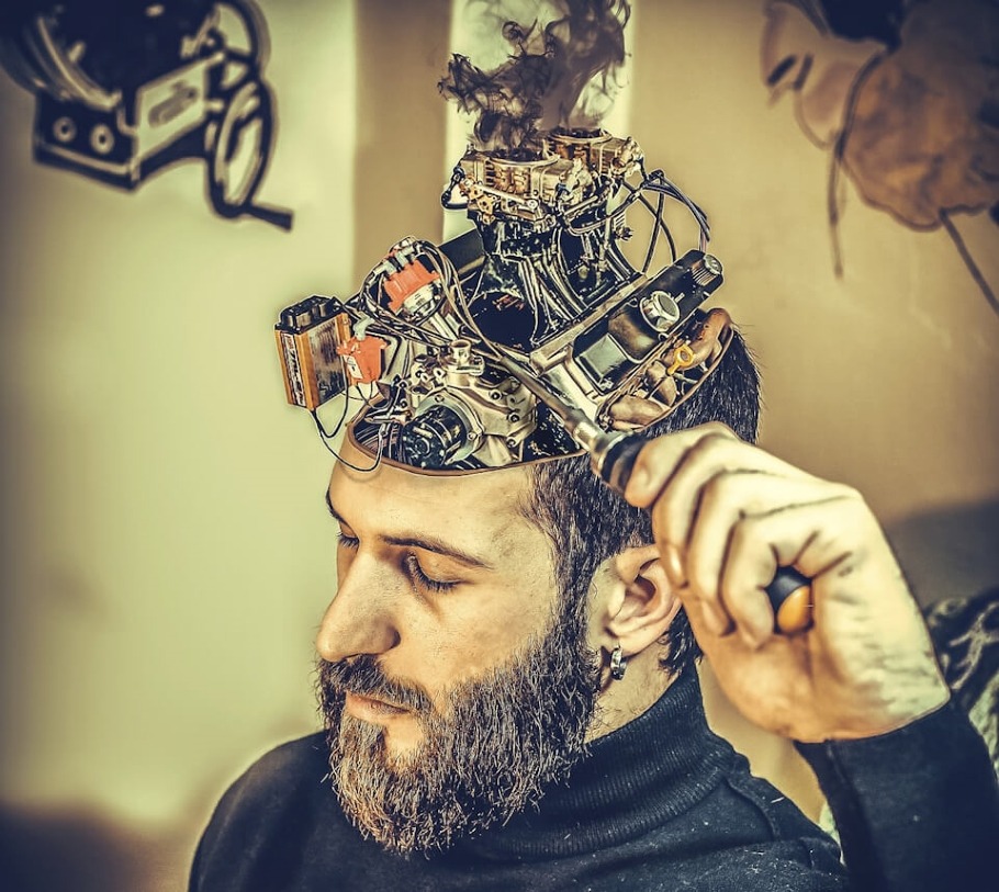 A depiction of a bearded man adjusting his mechanical brain.