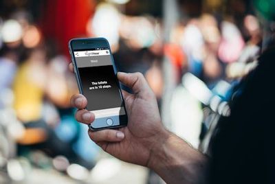 Person using the RightHear app on a cellphone - The screen message is advising the user that - The toilets are in ten steps - Image Credit: RightHear - right-hear.com