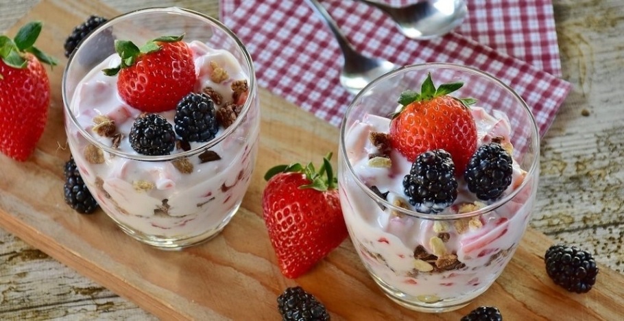 Strawberry Desserts in two glasses filled with yogurt, strawberries, blackberries and mixed nuts.