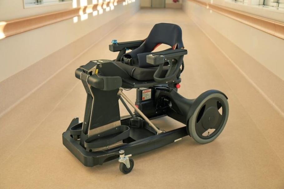 Qolo standing mobility device integrates exoskeleton and wheelchair functions. It supports standing and sitting with a passive assist mechanism for people with lower limb paralysis.